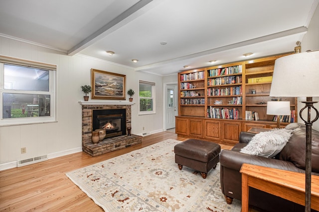 3145 Bembridge Rd, Columbus, OH 43221 - living room featuring ornamental molding, wood finished floors, baseboards, a brick fireplace, and beamed ceiling