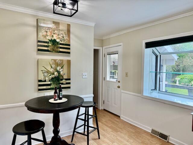 3145 Bembridge Rd, Columbus, OH 43221 - dining space with plenty of natural light, light wood finished floors, ornamental molding, and baseboards