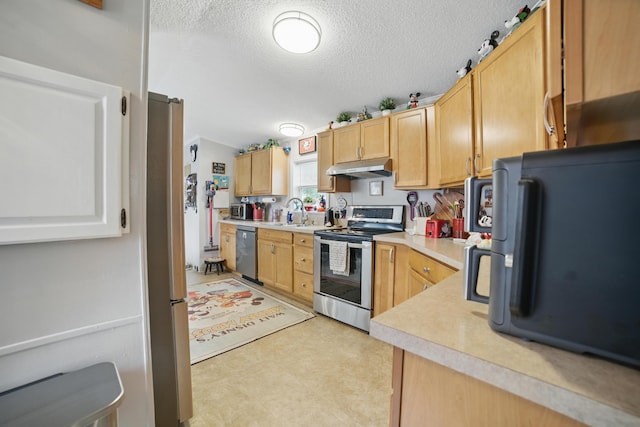 25 Ravine Ridge Dr, Delaware, OH 43015 - kitchen with stainless steel appliances, under cabinet range hood, a textured ceiling, light countertops, and light floors