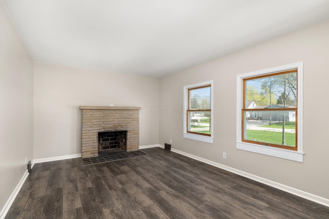 624 Bendle Ave, Shelby, OH 44875 - unfurnished living room featuring dark wood-style flooring, baseboards, and a fireplace