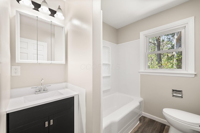 624 Bendle Ave, Shelby, OH 44875 - bathroom featuring wood finished floors, toilet, baseboards, vanity, and tub / shower combination