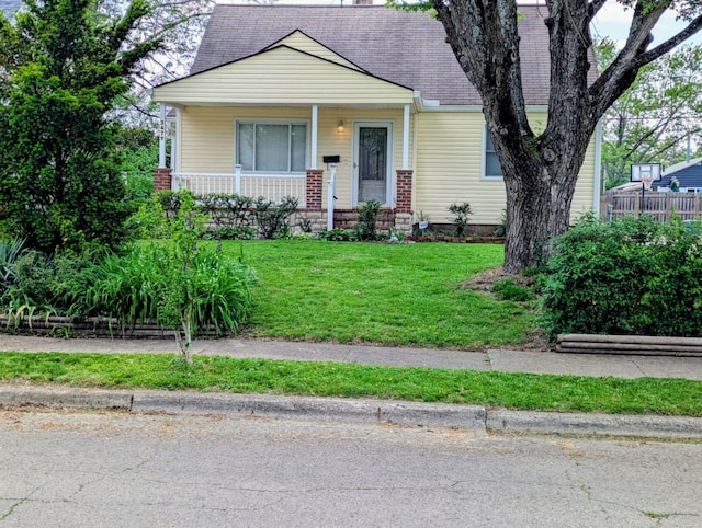 bungalow-style home with a porch, a front lawn, and a shingled roof