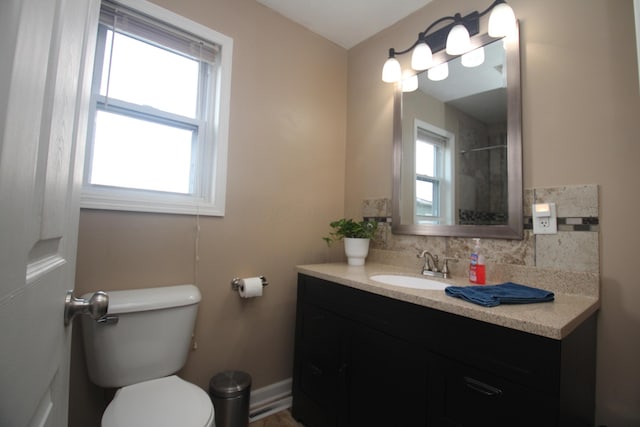 full bathroom with toilet, vanity, and a shower