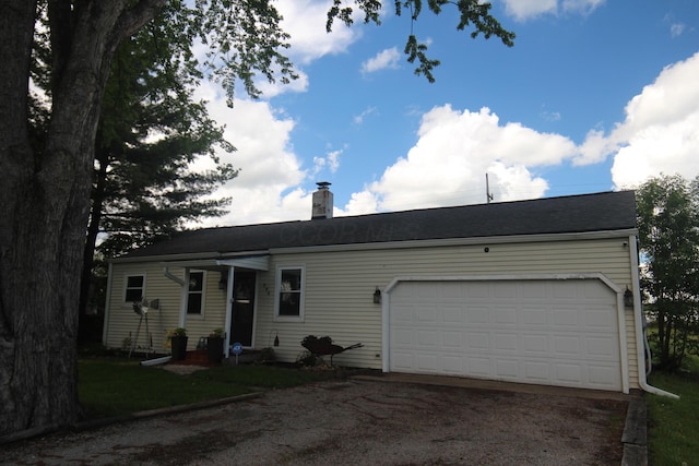 ranch-style house featuring driveway, a garage, and a chimney