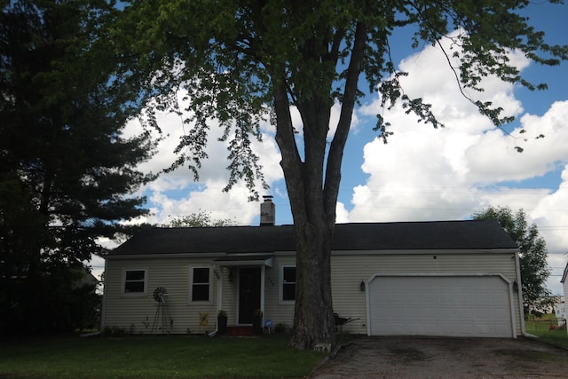 ranch-style home with a garage, driveway, a chimney, and a front yard