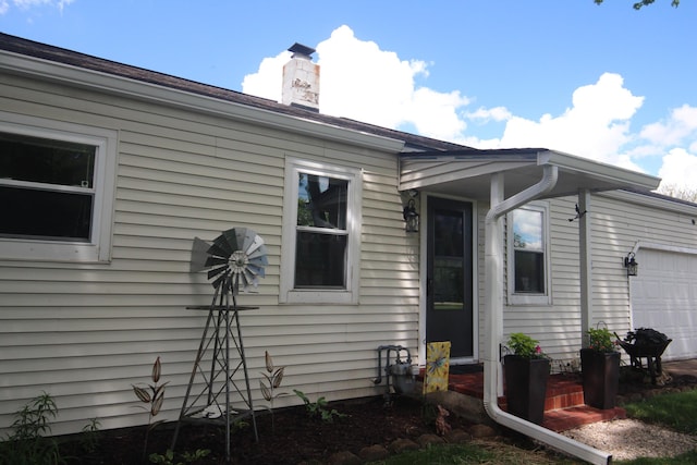 view of home's exterior with a garage and a chimney