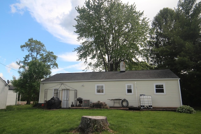 back of property with a yard, a gazebo, a chimney, and central air condition unit