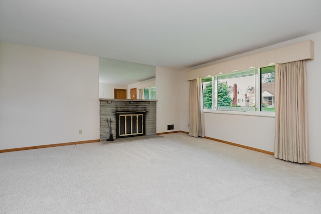 unfurnished living room with carpet flooring, a glass covered fireplace, and baseboards