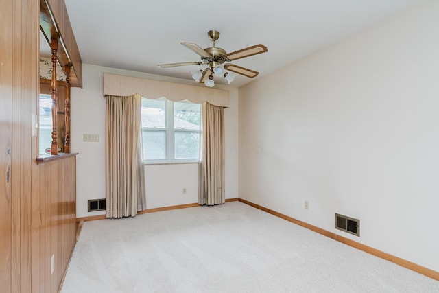 unfurnished room featuring ceiling fan, light colored carpet, and baseboards