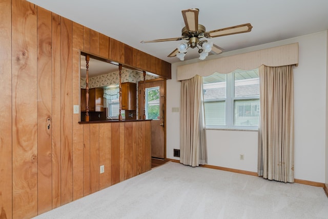 carpeted spare room featuring ceiling fan and baseboards