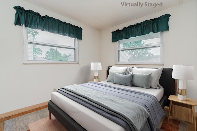 bedroom with wood finished floors and baseboards