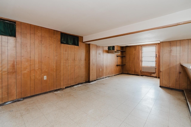 spare room with light floors and wooden walls