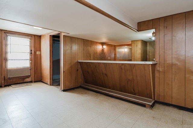 indoor dry bar featuring wooden walls and tile patterned floors