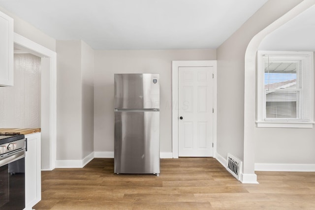 774 Congress St, Marion, OH 43302 - kitchen with appliances with stainless steel finishes, light wood-style flooring, white cabinets, and baseboards