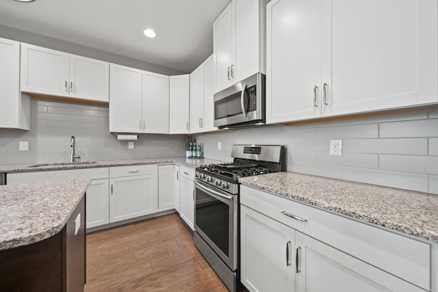 1070 Little Bear Pl, Lewis Center, OH 43035 - kitchen featuring stainless steel appliances, a sink, backsplash, white cabinets, and recessed lighting