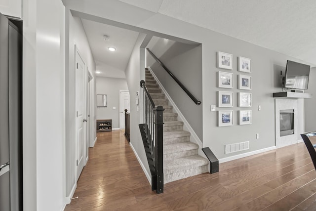 1070 Little Bear Pl, Lewis Center, OH 43035 - stairs with a glass covered fireplace, wood finished floors, baseboards, and recessed lighting