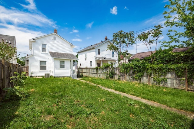 back of property featuring a chimney and cooling unit