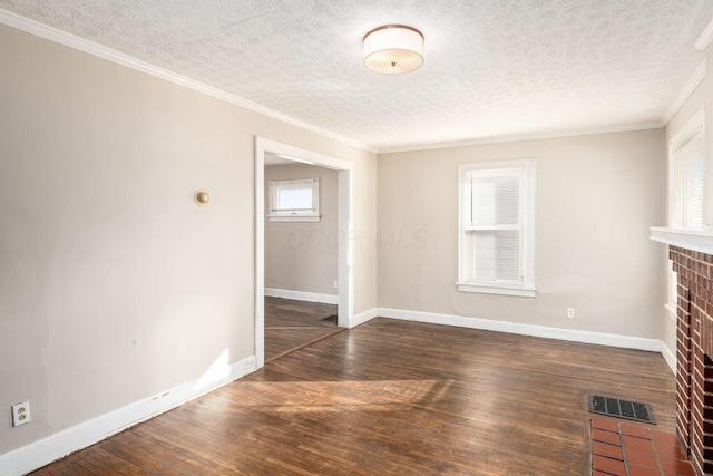 unfurnished living room featuring a brick fireplace, wood finished floors, a textured ceiling, baseboards, and ornamental molding