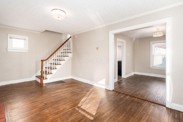 unfurnished room with dark wood-type flooring, stairway, baseboards, ornamental molding, and a textured ceiling