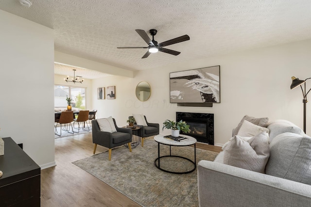 1993 Cumberland St, Newark, OH 43055 - living room with wood finished floors, a chandelier, ceiling fan, a high end fireplace, and a textured ceiling