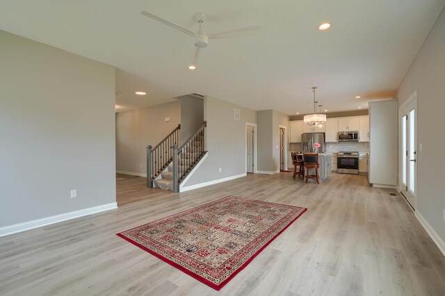 596 Courtright Dr E, Pickerington, OH 43147 - living room featuring light wood finished floors, baseboards, stairway, ceiling fan, and recessed lighting