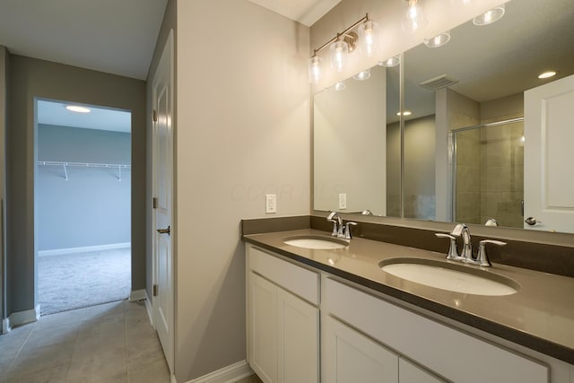 596 Courtright Dr E, Pickerington, OH 43147 - bathroom with a shower stall, double vanity, tile patterned flooring, a spacious closet, and baseboards