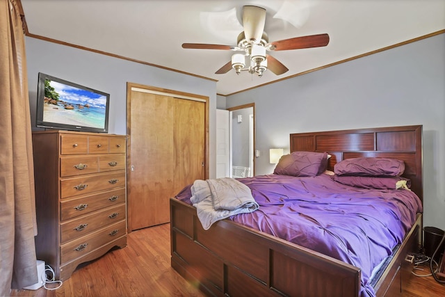 bedroom featuring crown molding, wood finished floors, a closet, and a ceiling fan