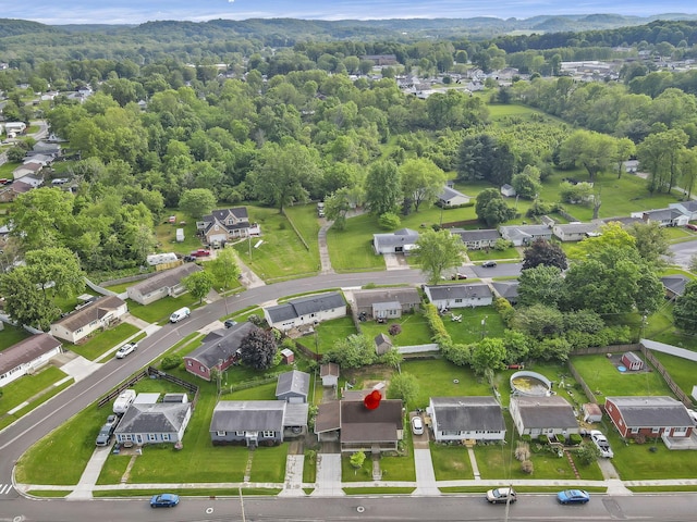 view of property location featuring nearby suburban area and a forest