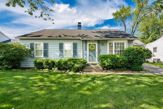 1512 Shanley Dr, Columbus, OH 43224 - view of front of home with a chimney, a front yard, and a shingled roof