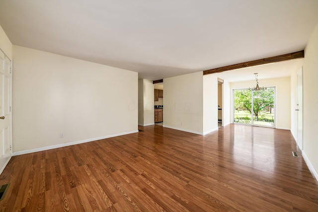 1512 Shanley Dr, Columbus, OH 43224 - unfurnished living room featuring a chandelier, dark wood-type flooring, and baseboards