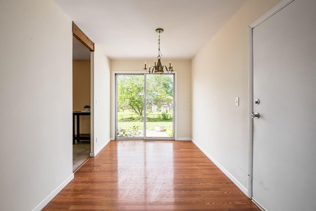 1512 Shanley Dr, Columbus, OH 43224 - unfurnished dining area featuring wood finished floors, a chandelier, and baseboards