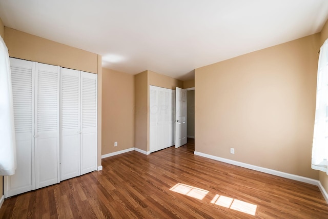 1512 Shanley Dr, Columbus, OH 43224 - unfurnished bedroom with wood finished floors, baseboards, and two closets