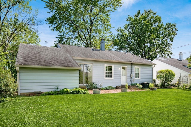 1512 Shanley Dr, Columbus, OH 43224 - rear view of house with a yard, a chimney, central air condition unit, and roof with shingles