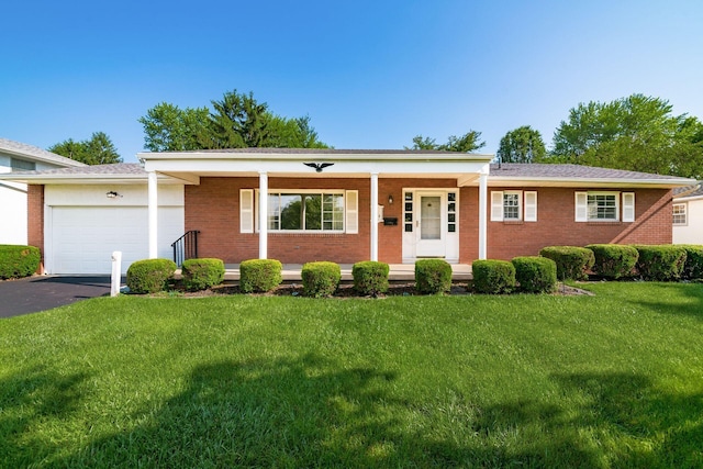 738 Stinson Dr, Columbus, OH 43214 - ranch-style house with covered porch, a garage, brick siding, a front yard, and driveway