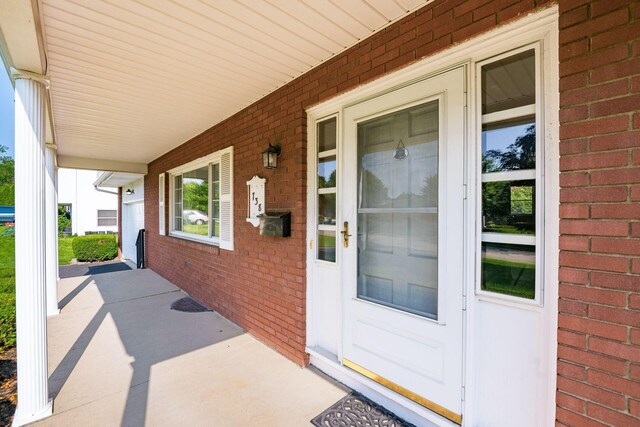 738 Stinson Dr, Columbus, OH 43214 - doorway to property featuring covered porch and brick siding