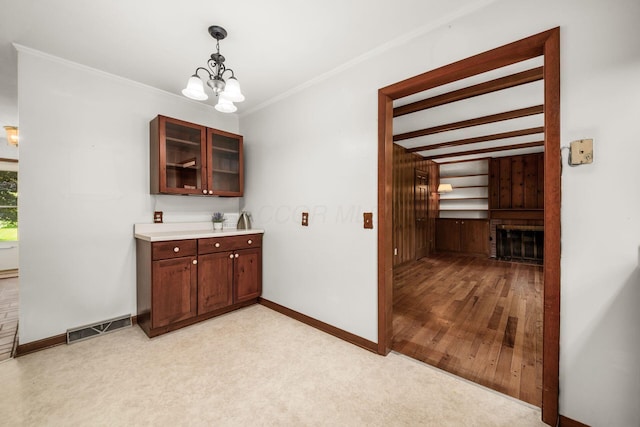 738 Stinson Dr, Columbus, OH 43214 - bar area with a chandelier, a fireplace, pendant lighting, crown molding, and light carpet