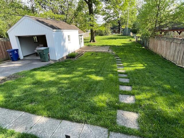 635 E Dominion Blvd, Columbus, OH 43214 - view of yard featuring an outdoor structure, a detached garage, and view of wooded area