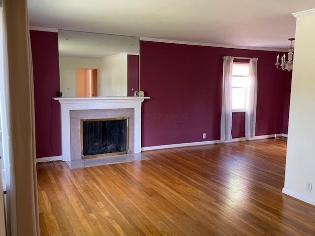 635 E Dominion Blvd, Columbus, OH 43214 - unfurnished living room with a chandelier, wood finished floors, baseboards, crown molding, and a fireplace with flush hearth