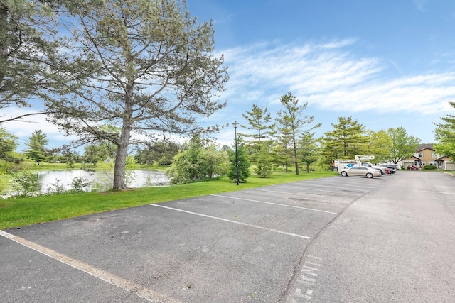 uncovered parking lot featuring a water view