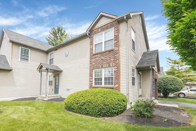 view of front of home with a front yard and brick siding