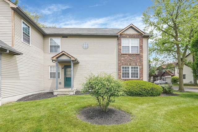view of front of house featuring a front lawn and brick siding