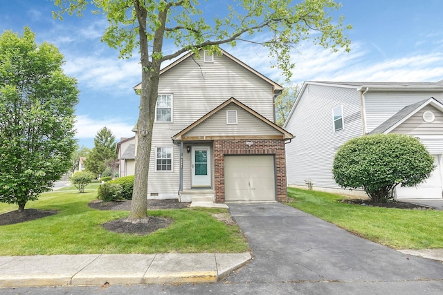 traditional home with a front yard, driveway, an attached garage, and brick siding