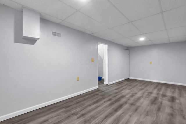 finished below grade area featuring a paneled ceiling, dark wood-style flooring, baseboards, and recessed lighting