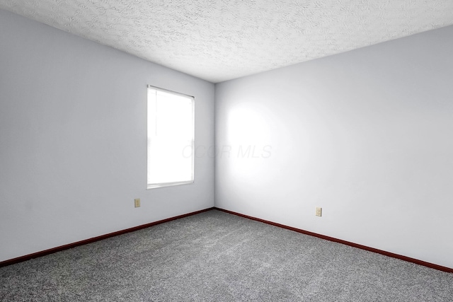carpeted spare room featuring baseboards and a textured ceiling