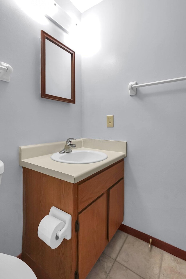 half bathroom featuring toilet, vanity, and tile patterned flooring
