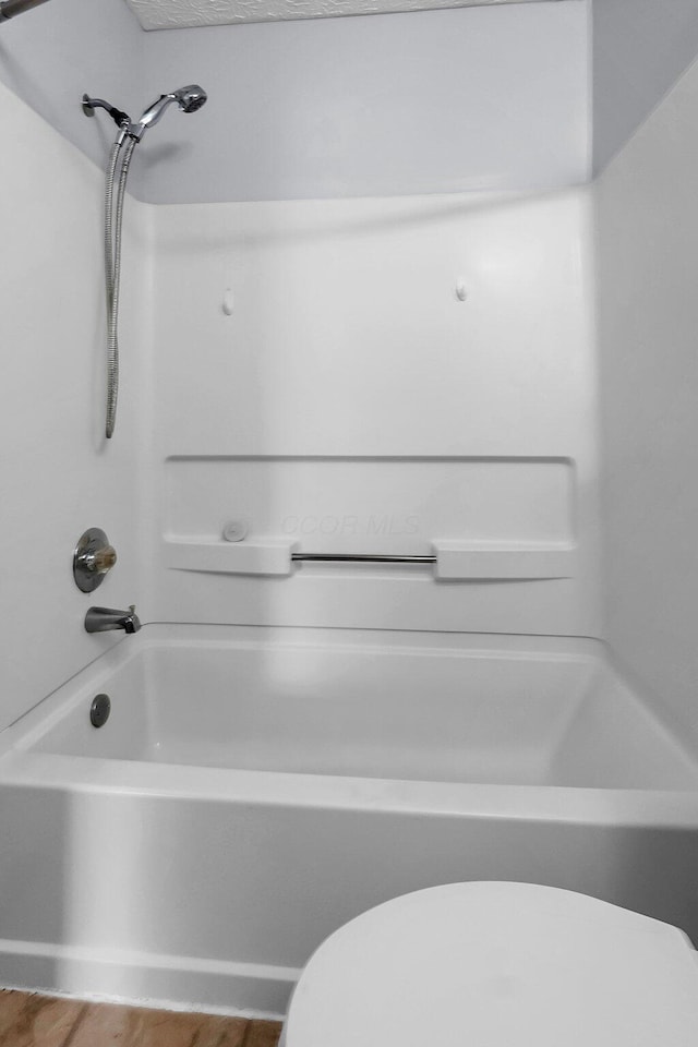 full bath featuring toilet and  shower combination