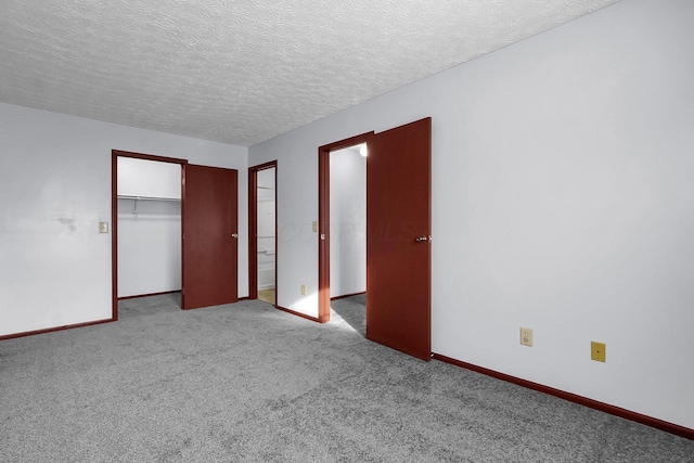 unfurnished bedroom with carpet floors, baseboards, a textured ceiling, and a closet
