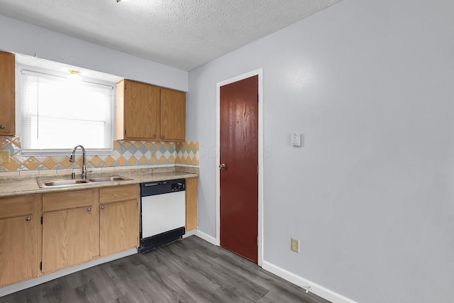 kitchen featuring white dishwasher, a sink, dark wood-type flooring, decorative backsplash, and light countertops