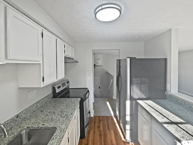 2620 Trailwind St, Grove City, OH 43123 - kitchen featuring stainless steel appliances, under cabinet range hood, dark wood-style flooring, white cabinets, and light stone counters