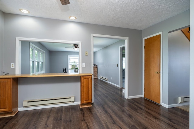 13216 Sheley Road Nw, Jeffersonville, OH 43128 - kitchen with ceiling fan, a baseboard heating unit, dark wood-type flooring, brown cabinetry, and a textured ceiling